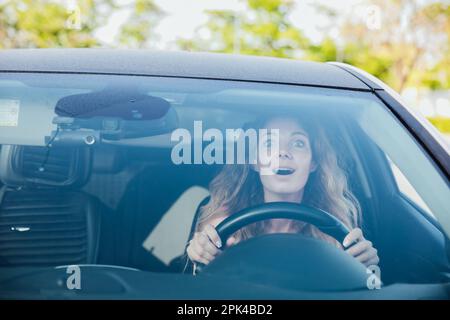 Eine schöne Autofahrerin, die mit Emotionen fährt Stockfoto