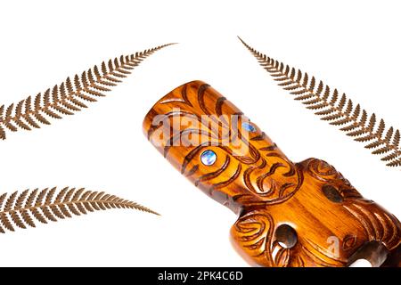 neuseeländisches Symbol, traditionelle maori-Schnitzereien und silberne Farnblätter, weißer Hintergrund, Nahaufnahme Stockfoto