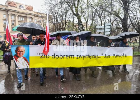 3. April 2023, Krakau, Polen: Die Menschen halten ein Banner mit der Aufschrift "Überwinde das Böse mit dem Guten", während sie an einem marsch zur Verteidigung des verstorbenen Papstes St. Johannes Paul II. Und anlässlich seines 18. Todestages. Krakau, Polen, am 2. April 2023. Im ganzen Land fanden Märsche statt, als Reaktion auf eine kürzliche journalistische Untersuchung des polnischen Fernsehsenders TVN24, die zeigte, dass der verstorbene Papst von den Skandalen der Kirchenpädophilie wusste und versuchte, diese zu vertuschen, indem er Priester in andere Diözesen überstellte, als er Erzbischof war Krakau. (Kreditbild: © Beata Zawrzel/ZUMA P. Stockfoto