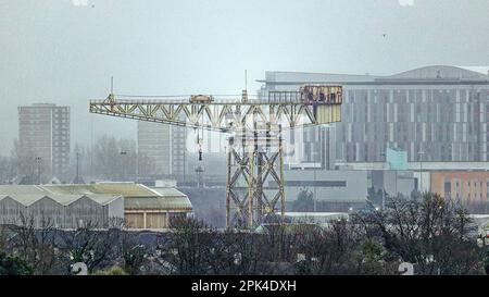 Glasgow, Schottland, Vereinigtes Königreich, 5. April 2023. UK Weather: Nass und neblig sah die Stadt hinter lokalen Wahrzeichen verschwinden, während die Aprilschauer schwirrten. Der Schiffbaukran Scotstoun barclay curle clyde titan im Schatten des Queen elizabeth Krankenhauses auf der anderen Flussseite in govan. Credit Gerard Ferry/Alamy Live News Stockfoto