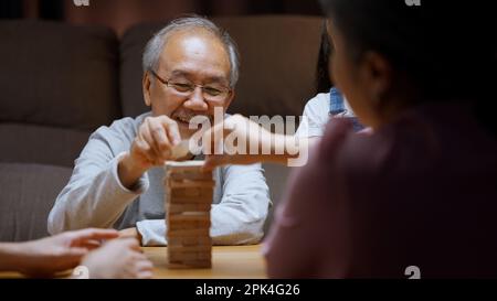Gesunder Großvater, der mit seiner Enkelin gern Holzspiel spielt Stockfoto