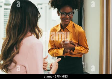 Junge asiatische Geschäftsfrau, die mit einem Kollegen des Unternehmens spricht Stockfoto
