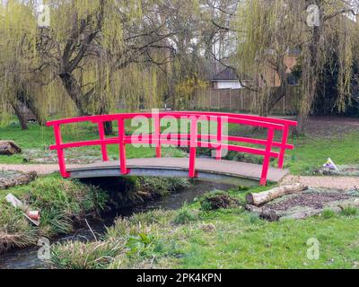 Bournemouth, Großbritannien - März 19. 2023: Rote Fußgängerbrücke über den Bourne Stream in den oberen Gärten. Stockfoto