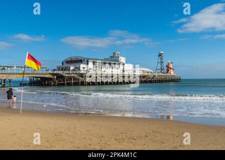 Bournemouth, Großbritannien - April 2. 2023: Eine RNLI-Rettungsschwimmer-Flagge am Bournemouth Beach vor dem Pier. Stockfoto