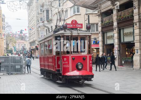 Istanbul, Türkei - 11. Dezember 2022: Berühmte alte rote Straßenbahn auf der Istiklal Caddesi Avenue. Stockfoto