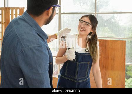 Zimmerlerin und Arbeiterin glücklich und Möbelherstellung in der Zimmerei Stockfoto