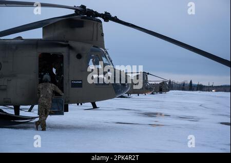 USA Soldaten der Bravo Company, 1. Bataillon, 52. Luftfahrtregiment, bereiten Sie CH-47 Chinooks auf einen Luftangriff während des Joint Pacific Multinational Readiness Complex-Alaska 23-02 auf dem Ladd Army Airfield, Ft. Vor. Wainwright, Alaska, 3. April 2023. JPMRC-AK 23-02 unterstützt Soldaten und Führer bei der Entwicklung und Verfeinerung der Taktiken, Techniken und Verfahren, die für einen erfolgreichen Einsatz unter abgelegenen und extremen arktischen Winterbedingungen und für die Bewältigung ökologischer und militärischer Herausforderungen erforderlich sind. (USA Air Force Photo von Senior Airman Patrick Sullivan) Stockfoto