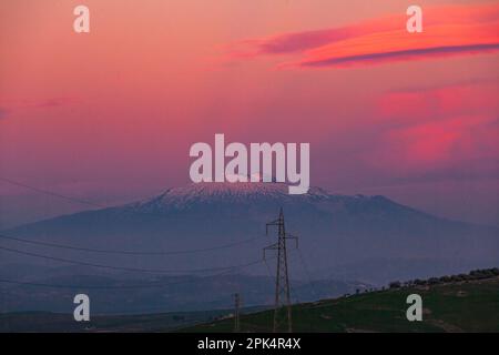 Sonnenuntergang über der Insel Sizilien mit Blick auf den Vulkan Ätna am rosa Himmel Stockfoto