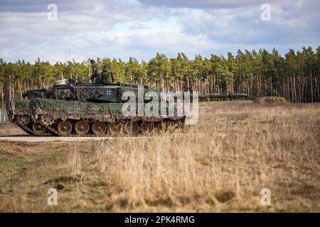 Deutsche Soldaten, die dem 93. Panzerlehr-Demonstrationsbataillon, 9. Panzerlehr-Brigade, 1. Panzerdivision, zugeteilt wurden, fuhren während einer kombinierten Feuerübung in Bemowo Piskie, Polen, am 3. April 2023 einen Leopard 2A6-Panzer auf das Gelände. Die Mission der 4. Infanterieabteilung in Europa besteht darin, sich an multinationalen Schulungen und Übungen auf dem ganzen Kontinent zu beteiligen und mit NATO-Verbündeten und regionalen Sicherheitspartnern zusammenzuarbeiten, um V Corps, Amerikas zukunftsgerichtetes Korps in Europa, mit Kampfkräften zu versorgen. (USA Armeenationalgarde (Foto von Sergeant John Schoebel) Stockfoto