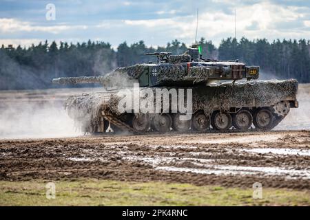 Deutsche Soldaten, die dem 93. Panzerlehr-Demonstrationsbataillon, 9. Panzerlehr-Brigade, 1. Panzerdivision, zugeteilt wurden, fuhren während einer kombinierten Feuerübung in Bemowo Piskie, Polen, am 3. April 2023 einen Leopard 2A6-Panzer auf das Gelände. Die Mission der 4. Infanterieabteilung in Europa besteht darin, sich an multinationalen Schulungen und Übungen auf dem ganzen Kontinent zu beteiligen und mit NATO-Verbündeten und regionalen Sicherheitspartnern zusammenzuarbeiten, um V Corps, Amerikas zukunftsgerichtetes Korps in Europa, mit Kampfkräften zu versorgen. (USA Armeenationalgarde (Foto von Sergeant John Schoebel) Stockfoto