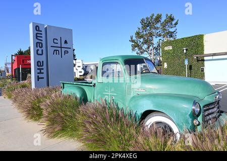 COSTA MESA, KALIFORNIEN: 4. April 2023: Alter GMC Truck und Schild am Camp Retail Campus in Costa Mesa. Stockfoto