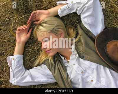Porträt eines jungen attraktiven Cowgirls auf der Ranch am Sommertag Stockfoto