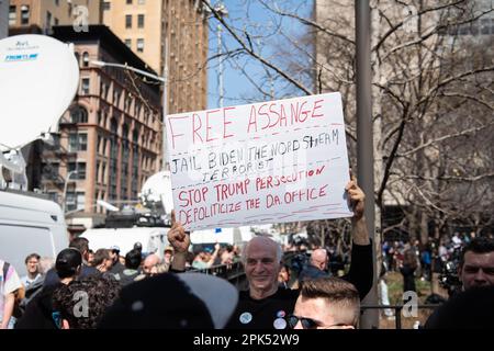 Ein Mann mit einem Schild, auf dem steht: "Freies Assange Gefängnis Biden, der Nord Stream Terrorist" und "Stopp Trump Verfolgung, entpolitisiert die Staatsanwaltschaft. Büro vor der Anklageerhebung des ehemaligen Präsidenten in Manhattan. Stockfoto