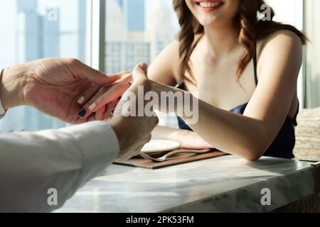 Ein Paar, das ein romantisches Abendessen in der Dachrestaurant-Bar des Wolkenkratzers verliebte Stockfoto
