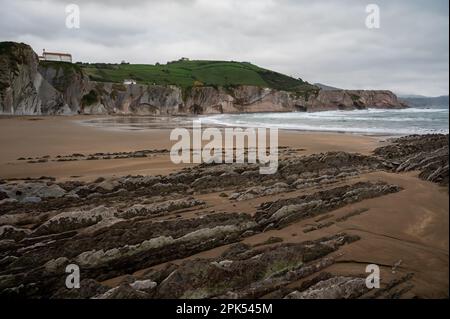 Blick auf steil geneigte Schichten von Flysch-geologischer Formation an der Atlantikküste bei Zumaia bei Ebbe, Baskenland, Spanien Stockfoto