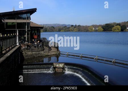 Roath Park Café am See mit Sitzgelegenheiten im Freien. Überlaufwaage/Schleuse. April 2023. Frühling. Stockfoto