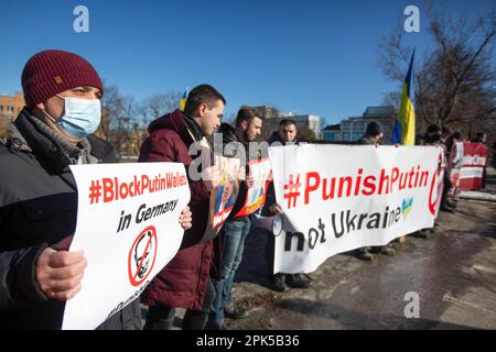 Kiew, Ukraine. 14. Februar 2022. Aktivisten mit Plakaten nehmen an einer Kundgebung Teil, bei der der deutsche Kanzler Olaf Scholz Sanktionen gegen Russland verhängt, weil mit einer Invasion der Ukraine in Kiew gedroht wird. Die Kundgebung fand während des offiziellen Besuchs von Olaf Scholz in Kiew am 14. Februar 2022 statt. (Foto: James McGill/SOPA Images/Sipa USA) Guthaben: SIPA USA/Alamy Live News Stockfoto