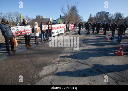 Kiew, Ukraine. 14. Februar 2022. Aktivisten mit Plakaten nehmen an einer Kundgebung Teil, bei der der deutsche Kanzler Olaf Scholz Sanktionen gegen Russland verhängt, weil mit einer Invasion der Ukraine in Kiew gedroht wird. Die Kundgebung fand während des offiziellen Besuchs von Olaf Scholz in Kiew am 14. Februar 2022 statt. (Foto: James McGill/SOPA Images/Sipa USA) Guthaben: SIPA USA/Alamy Live News Stockfoto