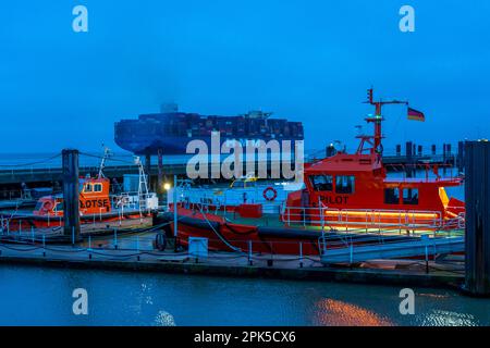 Pilotenboote, Pilotenboote, an der Anlegestelle der Alten Liebe im Hafen von Cuxhaven, Containerschiff HMM Rotterdam geht in die Elbe, Niedersachsen, Germ Stockfoto