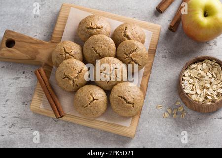 Gedünstete Haferflocken-Kekse mit Apfel und Zimt auf hellgrauem, strukturiertem Hintergrund. Gesundes hausgemachtes Essen Stockfoto