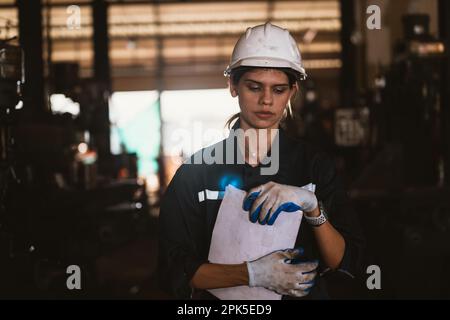 Müde Ingenieurin, die in der Fabrik arbeitet Stockfoto