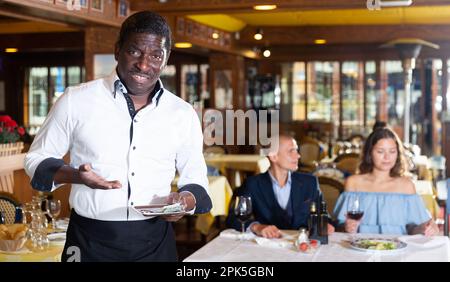 Kellner, der Unmut mit kleinem Trinkgeld ausdrückt Stockfoto