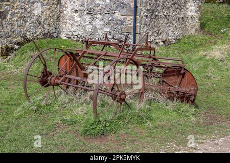 Ein altes, verrostetes, stillgelegtes Stück landwirtschaftlicher Ausrüstung, das vor einer Scheune in Malhamdale gefunden wurde Stockfoto