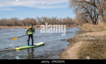 Der südliche Platte River in Colorado im Frühling paddelt flussaufwärts auf einem aufblasbaren Stand-Up-Paddleboard Stockfoto