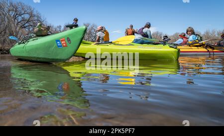 Evans, CO, USA - 1. April 2023: Eine Gruppe von Kajakfahrern ruht sich auf einer Sandbank nach dem Staudamm während der Frühlingspaddeltour auf dem South Platte Rive aus Stockfoto