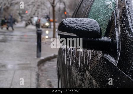 Auto-Seitenspiegel in Montreal mit Eis und Eiszapfen bedeckt Stockfoto