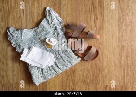 Stilvolle Kinderkleidung, Schuhe und Accessoires auf Holzhintergrund, flach liegend Stockfoto