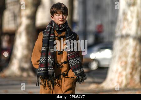 Frau, die im Winter auf dem Platz des Königs Tomislav (Trg Kralja Tomislava) spazierend ist. Zagreb, Kroatien. Stockfoto