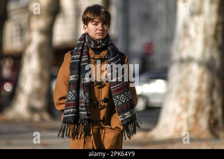 Frau, die im Winter auf dem Platz des Königs Tomislav (Trg Kralja Tomislava) spazierend ist. Zagreb, Kroatien. Stockfoto