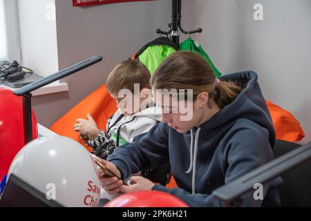 Kinder sitzen an einem Tisch mit Laptops und Tablets im Klassenzimmer. Offizielle Eröffnung des Digital Learning Center in Lemberg Higher Professional School of Computer Technologies and Construction, das von der internationalen humanitären Organisation Save the Children mit Unterstützung des norwegischen Außenministeriums gegründet wurde. Das Ziel des Digital Learning Center ist der sichere Zugang von Kindern im Alter von 6 bis 17 Jahren zum Fernunterricht und der Zugang zu interaktiver nichtformaler Bildung. Das digitale Lernzentrum gewährleistet den kontinuierlichen Zugang der Kinder zu Bildung und die Sozialisierung interner di Stockfoto