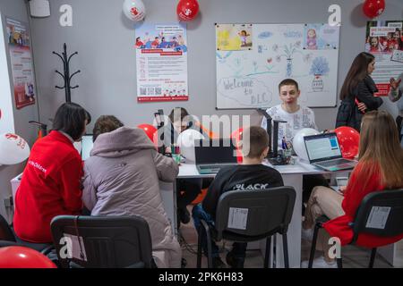 Kinder sitzen mit Laptops und Tablets an einem Tisch in einem Klassenzimmer Offizielle Eröffnung des Digital Learning Center in Lemberg Higher Professional School of Computer Technologies and Construction, das von der internationalen humanitären Organisation Save the Children mit Unterstützung des norwegischen Außenministeriums gegründet wurde. Das Ziel des Digital Learning Center ist der sichere Zugang von Kindern im Alter von 6 bis 17 Jahren zum Fernunterricht und der Zugang zu interaktiver nichtformaler Bildung. Das digitale Lernzentrum gewährleistet den kontinuierlichen Zugang der Kinder zu Bildung und die Sozialisierung der internen Dis Stockfoto