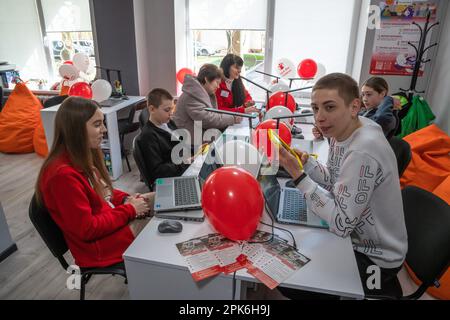 Kinder sitzen an einem Tisch mit Laptops und Tablets im Klassenzimmer. Offizielle Eröffnung des Digital Learning Center in Lemberg Higher Professional School of Computer Technologies and Construction, das von der internationalen humanitären Organisation Save the Children mit Unterstützung des norwegischen Außenministeriums gegründet wurde. Das Ziel des Digital Learning Center ist der sichere Zugang von Kindern im Alter von 6 bis 17 Jahren zum Fernunterricht und der Zugang zu interaktiver nichtformaler Bildung. Das digitale Lernzentrum gewährleistet den kontinuierlichen Zugang der Kinder zu Bildung und die Sozialisierung interner di Stockfoto