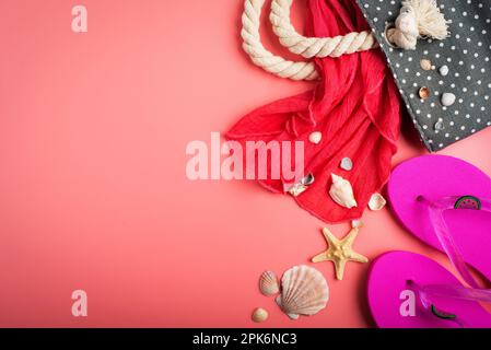 Flip-Flops und Strandtasche mit Muscheln und Seesternen auf pinkfarbenem Hintergrundmodell Stockfoto