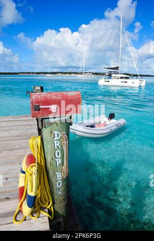 Landeplatz und Briefkasten von Warderick Wells, im Hintergrund ein Segelkatamaran, Bahamas und Exuma Cays Land und Sea National Park, Bahamas Stockfoto