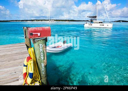 Landeplatz und Briefkasten von Warderick Wells, im Hintergrund ein Segelkatamaran, Bahamas und Exuma Cays Land und Sea National Park, Bahamas Stockfoto