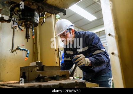 Techniker, der Roboterarme im Industriebetrieb prüft und steuert Stockfoto