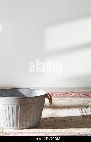 Dieser Raum bietet eine ruhige Atmosphäre mit Tageslicht. Auf dem Tisch befinden sich Tontöpfe, Glasflaschen, Kaffee und verschiedene Gegenstände. Stockfoto