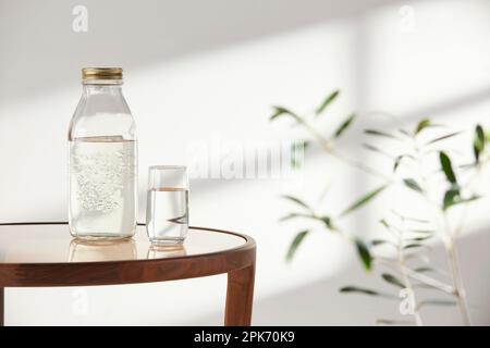 Dieser Raum bietet eine ruhige Atmosphäre mit Tageslicht. Auf dem Tisch befinden sich Tontöpfe, Glasflaschen, Kaffee und verschiedene Gegenstände. Stockfoto