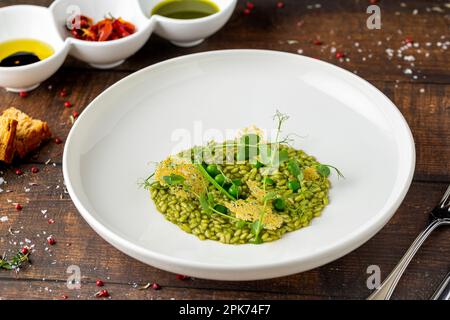 Erbsenrisotto auf weißem Porzellanteller in einem Feinschmeckerrestaurant Stockfoto