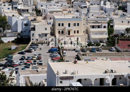 IOS, Griechenland - 26. Mai 2021 : Blick auf verschiedene Gebäude und einen Parkplatz im Dorf iOS Greece Stockfoto