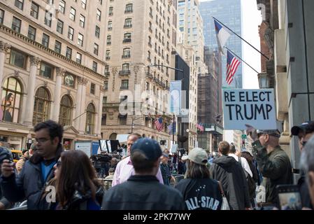 Mann zeigt doppelseitiges Trump 4 Prez / Re elect Trump Schild auf Busy 5. Ave NYC, am Morgen der Trump Anklageerhebung, 04. April 2023. Stockfoto