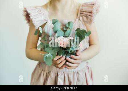 Ein Mädchen, das einen Strauß Eukalyptus und Nelke in der Hand hält Stockfoto