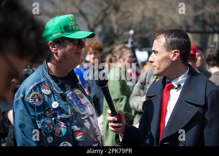 Reporter interviewt Mann mit Präsident Trump Buttons, vor dem Manhattan Criminal Court House, New York City, am 04. April 2023. Stockfoto
