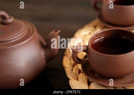 Teezeremonie. Traditionelles Asiatisches Teeutensil, Serviert Authentisches Set. Person, die Tee von der Teekanne aus brauner Keramik bis zur Teekanne einschenkt. Bambusschale. Lifestyle. Wir Stockfoto