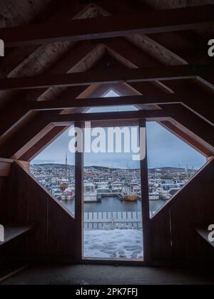 Tromso, Norwegen - 2020. Januar: Blick von einer Holzhütte auf den Yachthafen von Tromsdalshavna während der Polarnacht. Landschaft des Polarkreises im Winter. Nein. Nein Stockfoto