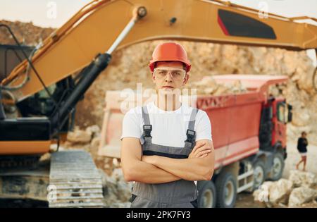 Porträt eines Arbeiters in Berufsuniform, der tagsüber auf der Leihgrube steht Stockfoto